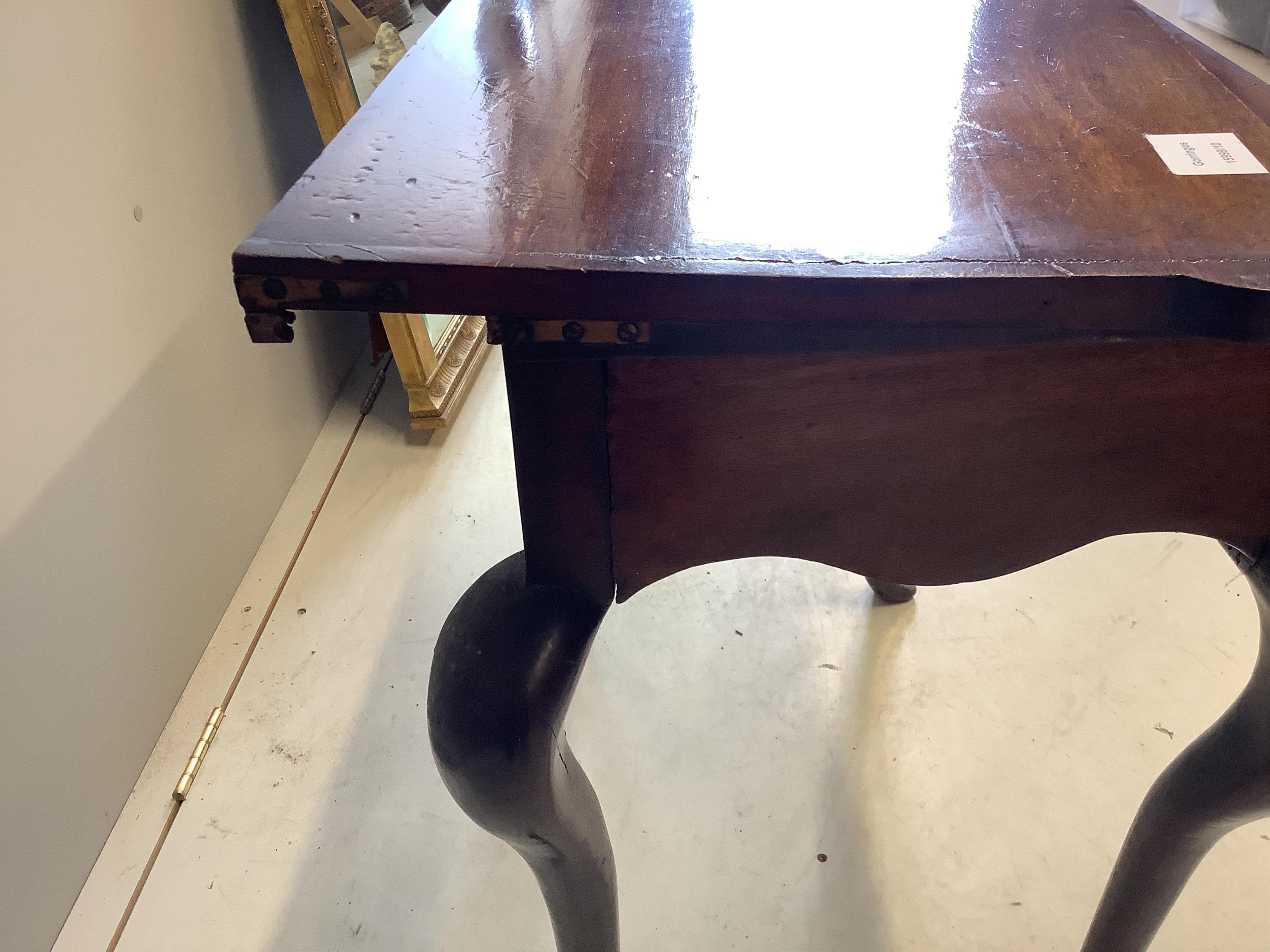 A George III mahogany folding tea table, on cabriole legs, width 67cm, depth 37cm, height 72cm. Condition - poor to fair